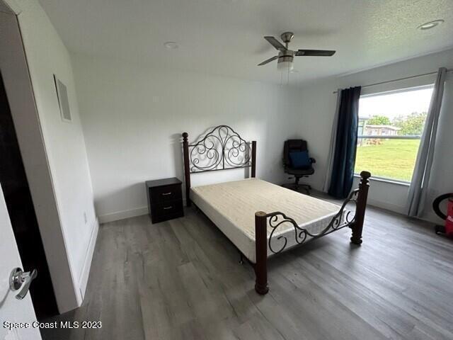 520 Atz Road, Unit COTTAGE Malabar, FL 32950 - Photo 14 of 25 a bed sitting in a bedroom next to a window