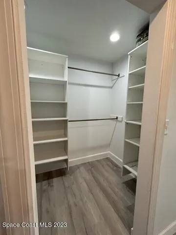 a view of walk in closet with empty racks