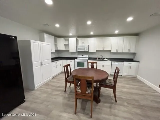 a kitchen with a table chairs refrigerator and microwave