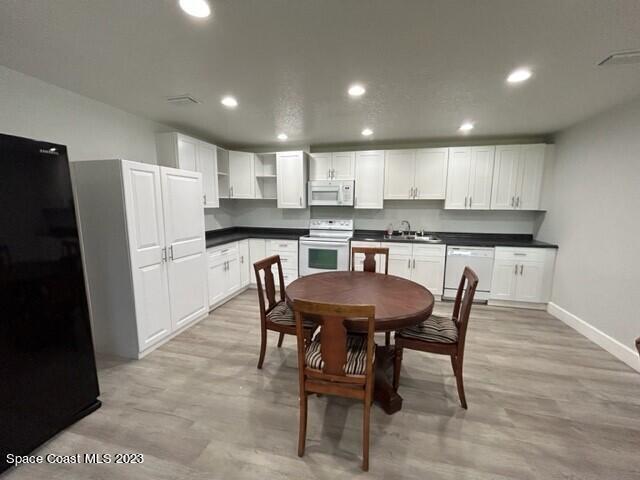 520 Atz Road, Unit COTTAGE Malabar, FL 32950 - Photo 6 of 25 a kitchen with a table chairs refrigerator and microwave