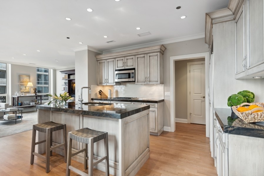 10 East Delaware Place, Unit 21D Chicago, IL 60611 - Photo 11 of 33 a kitchen with granite countertop a sink stove and cabinets