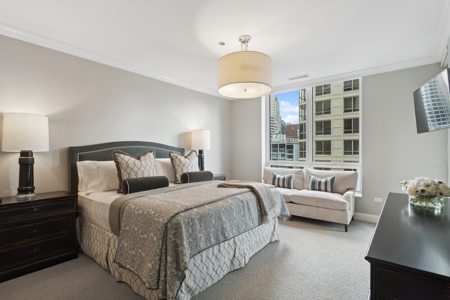 10 East Delaware Place, Unit 21D Chicago, IL 60611 - Photo 15 of 33 a bedroom with bed and a large window