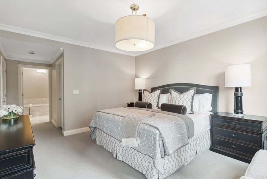 10 East Delaware Place, Unit 21D Chicago, IL 60611 - Photo 16 of 33 a bedroom with a bed and a chandelier