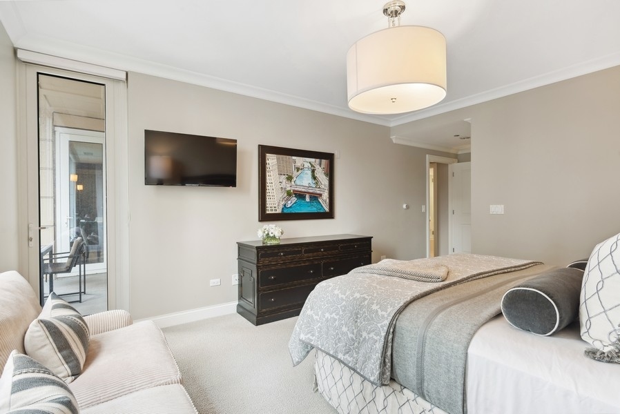 10 East Delaware Place, Unit 21D Chicago, IL 60611 - Photo 17 of 33 a bedroom with a bed and a flat screen tv