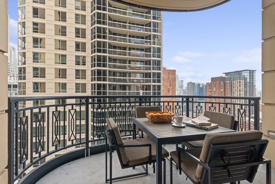 10 East Delaware Place, Unit 21D Chicago, IL 60611 - Photo 18 of 33 a view of a balcony with a dining table and chairs