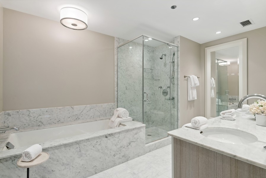 10 East Delaware Place, Unit 21D Chicago, IL 60611 - Photo 19 of 33 a bathroom with a granite countertop sink a toilet and shower