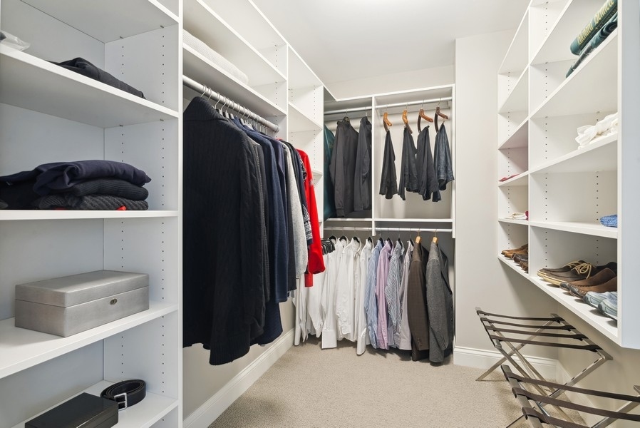 10 East Delaware Place, Unit 21D Chicago, IL 60611 - Photo 21 of 33 a view of walk in closet with clothes and shoes