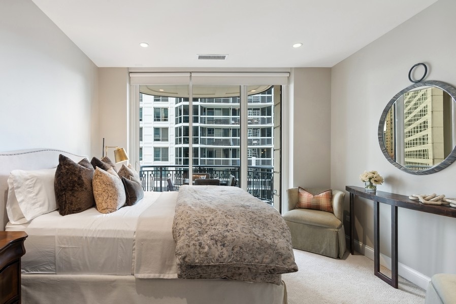 10 East Delaware Place, Unit 21D Chicago, IL 60611 - Photo 22 of 33 a bedroom with a bed a mirror and a large window