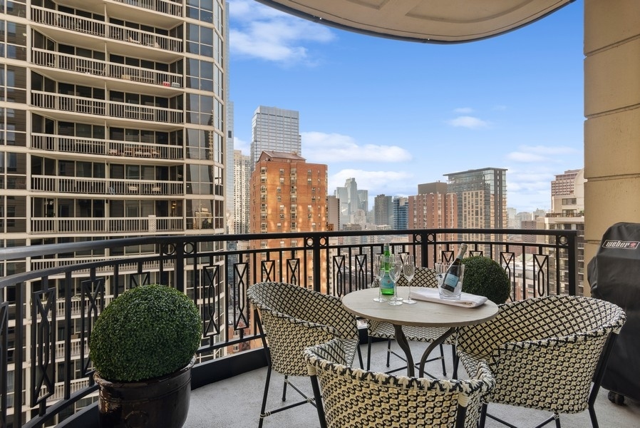 10 East Delaware Place, Unit 21D Chicago, IL 60611 - Photo 9 of 33 a balcony with a table and chairs