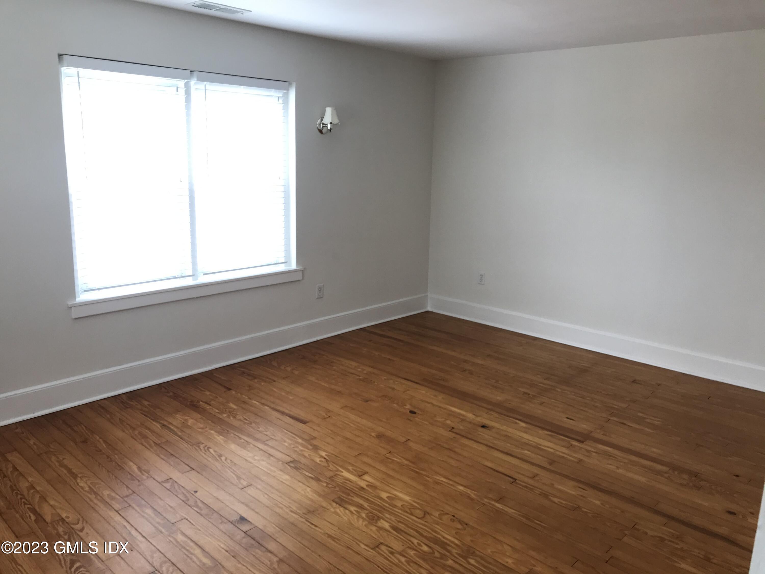 62 Valley Road Cos Cob, CT 06807 - Photo 4 of 16 an empty room with wooden floor and windows
