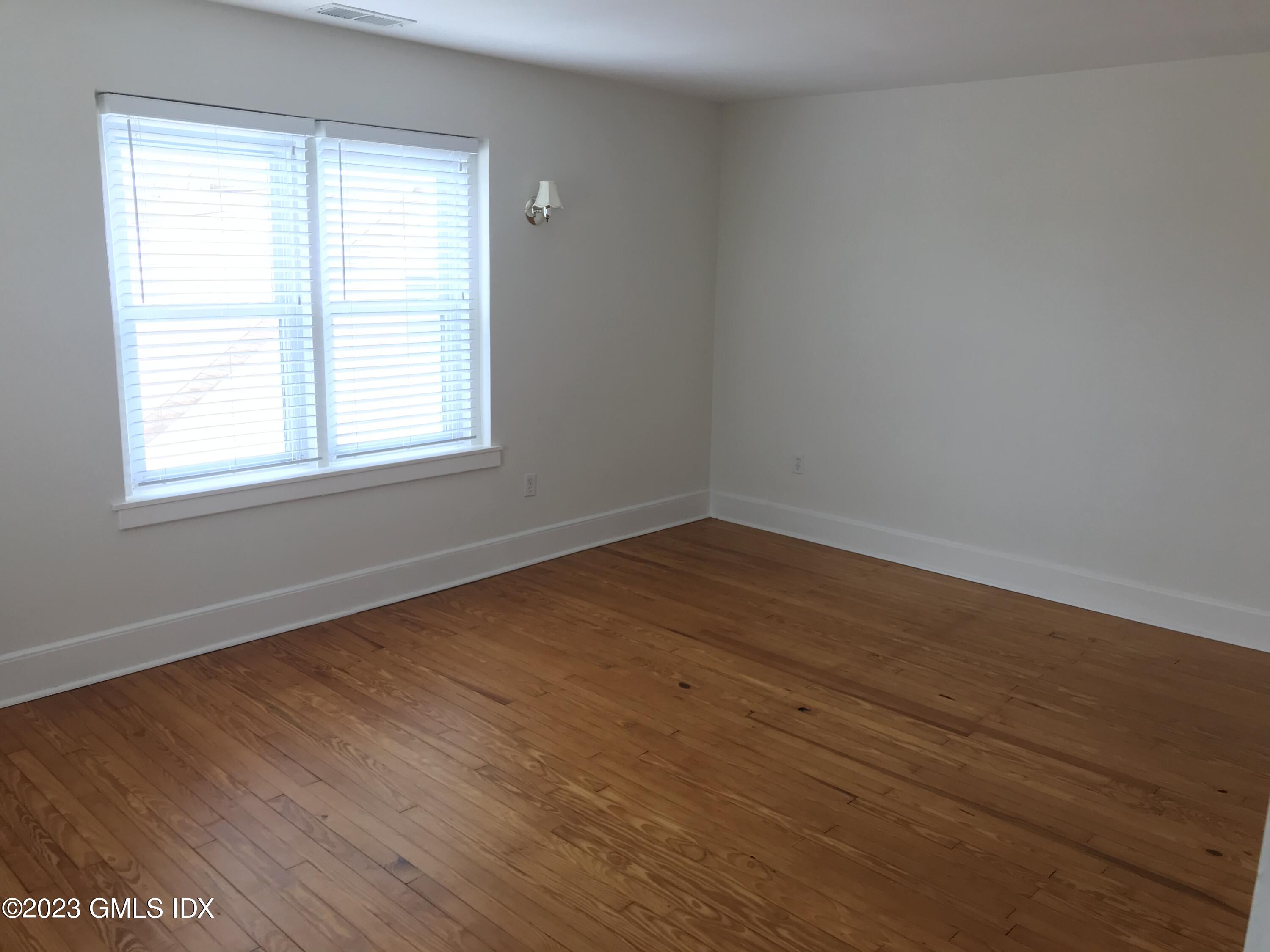 62 Valley Road Cos Cob, CT 06807 - Photo 5 of 16 an empty room with wooden floor and windows
