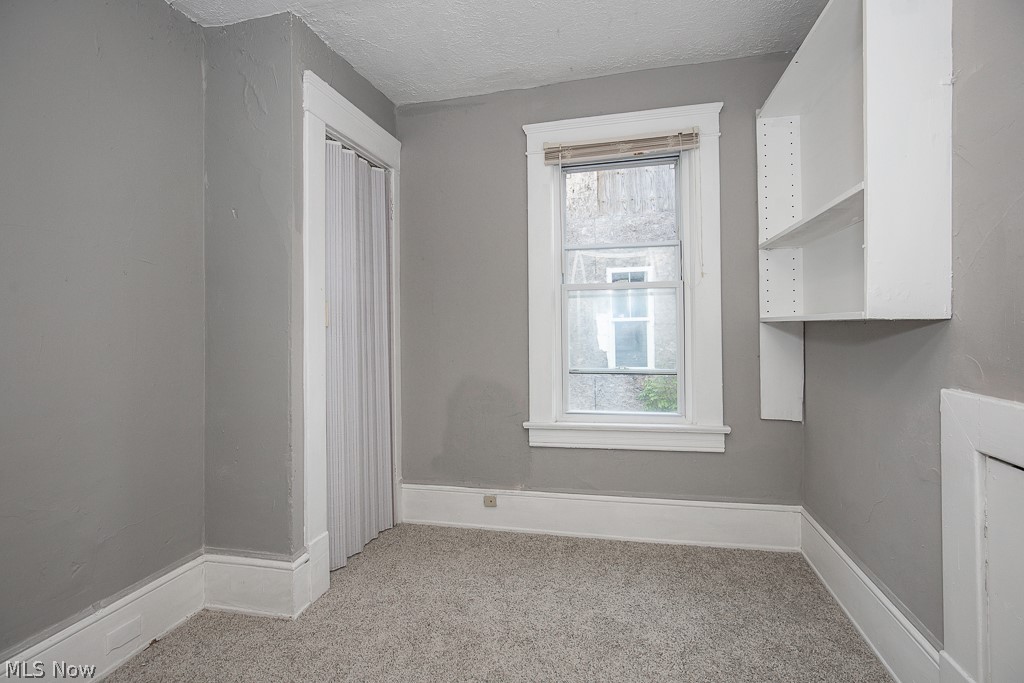 1892 Beersford Road Cleveland, OH 44112 - Photo 19 of 47 Carpeted empty room with a textured ceiling
