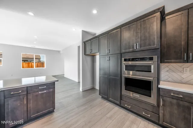 a kitchen with stainless steel appliances granite countertop a refrigerator and a stove top oven