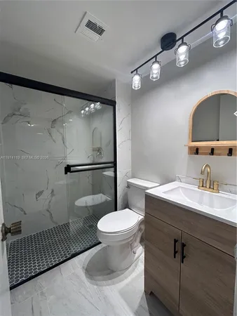 an empty room with wooden floor chandelier fan and windows