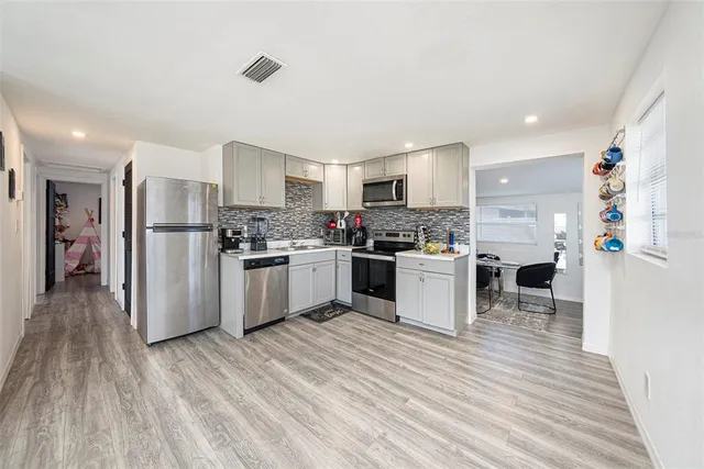 a kitchen with a refrigerator and a stove top oven