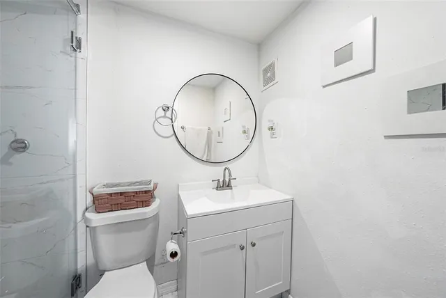 a bathroom with a toilet a sink and mirror