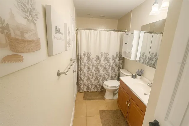 a bathroom with a sink a toilet and shower curtain