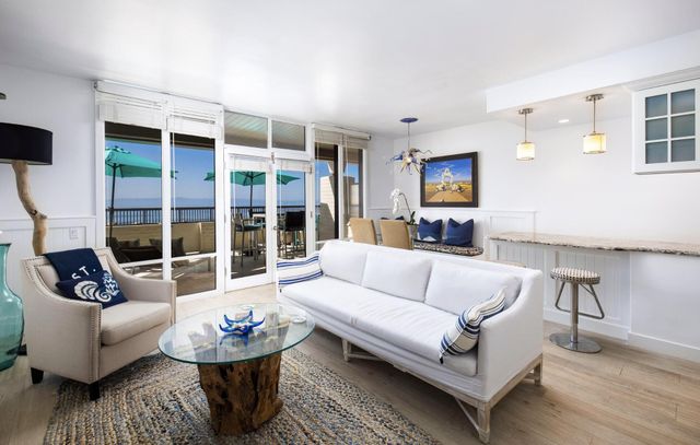 a living room with furniture a flat screen tv and a large window