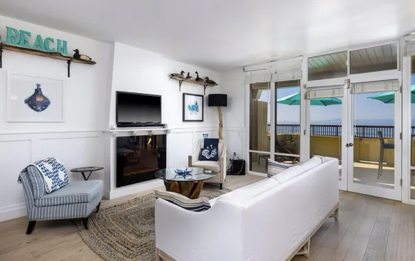 a living room with furniture fireplace and large windows