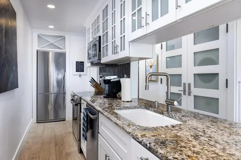 a bedroom with a bed and a flat tv screen on dresser