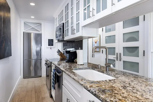 a bedroom with a bed and a flat tv screen on dresser