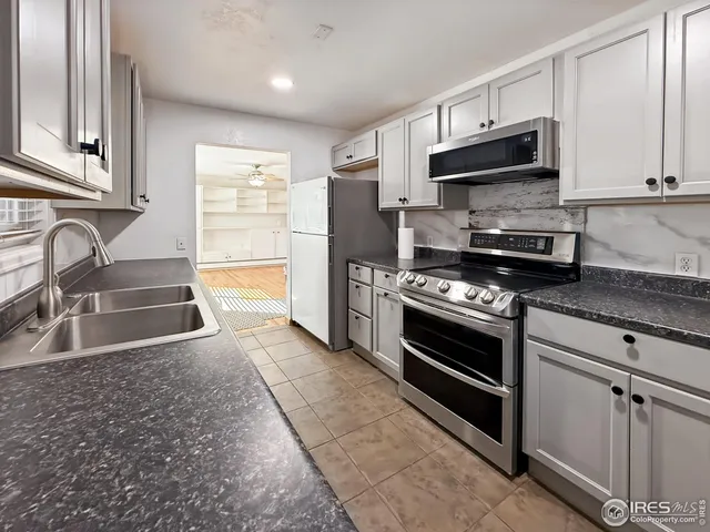 a kitchen with stainless steel appliances a stove sink and microwave