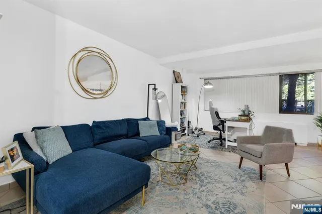 a living room with furniture a rug and a window