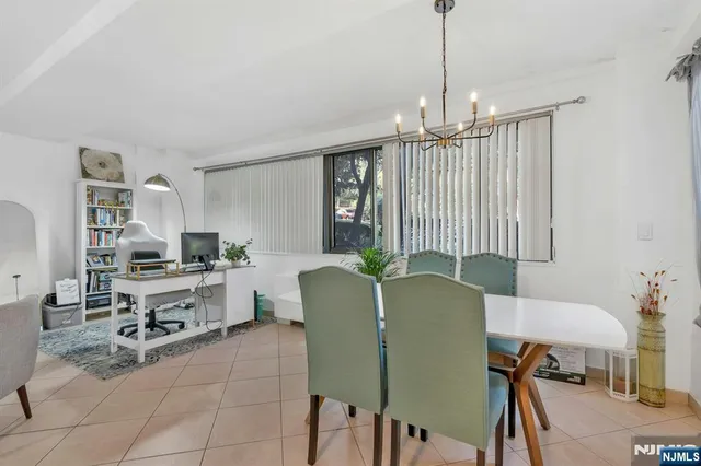 a living room with furniture a chandelier and a flat screen tv