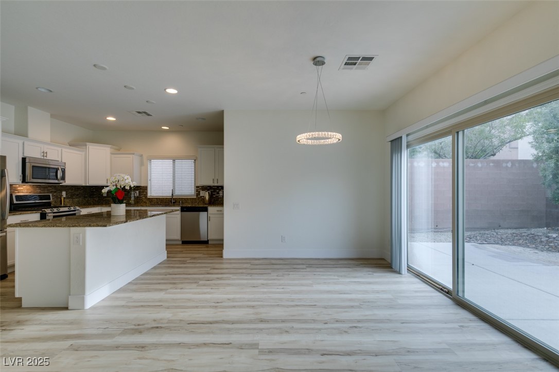 2617 Courgette Way Henderson, NV 89044 - Photo 19 of 52 View of kitchen, dining area with a huge sliding door to access the backyard with a Japanese style garden