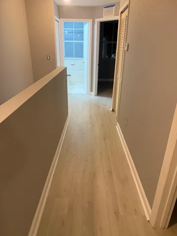 a view of a hallway with wooden floor