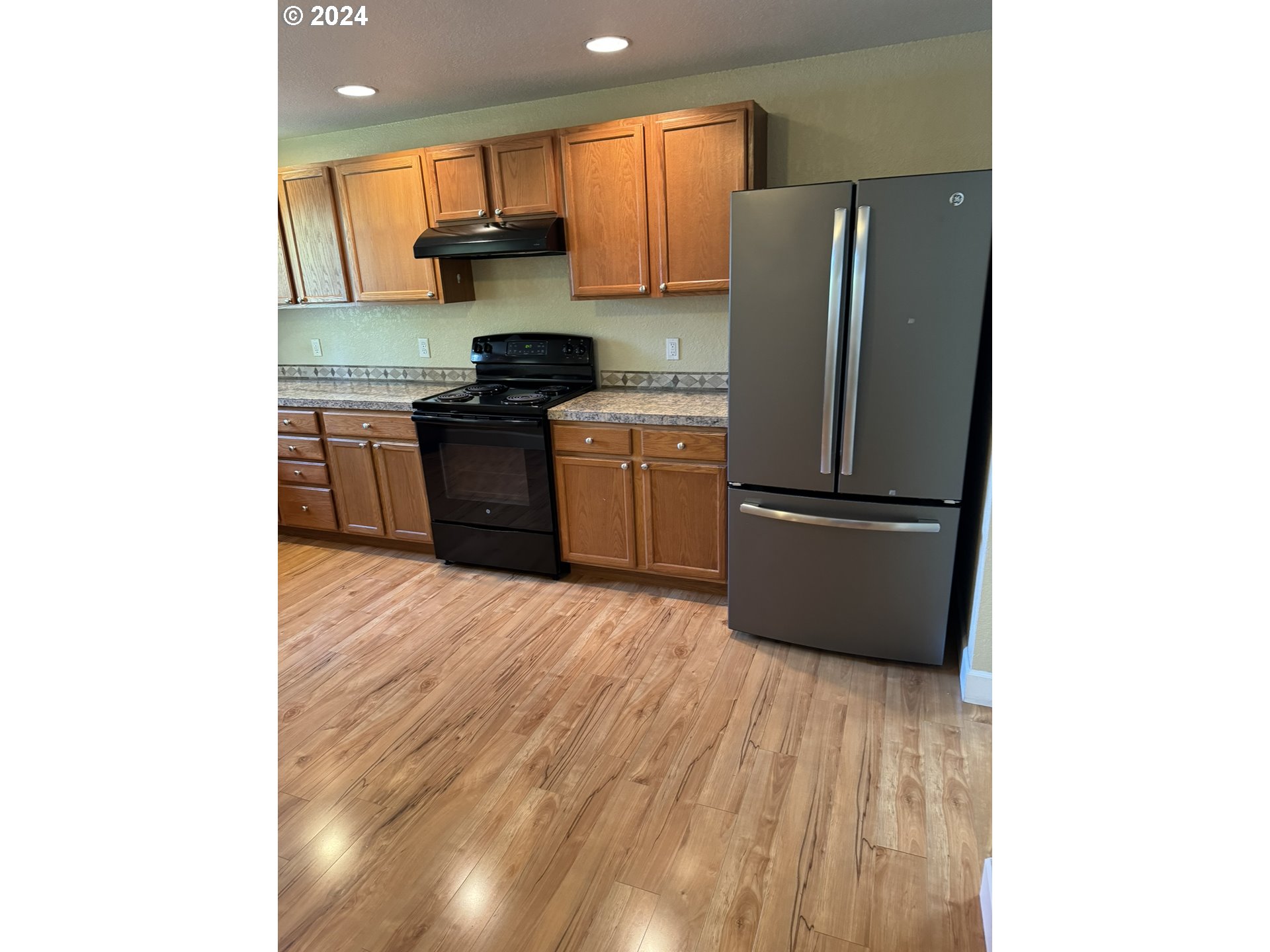395 Irving Road Eugene, OR 97404 - Photo 4 of 37 a kitchen with a refrigerator and a stove top oven