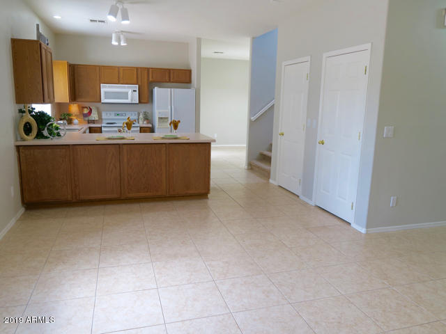 10442 East Butte Street Apache Junction, AZ 85120 - Photo 11 of 49 a room with kitchen island granite countertop a sink a counter top space and stainless steel appliances