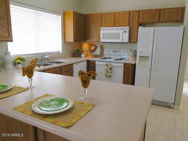 10442 East Butte Street Apache Junction, AZ 85120 - Photo 13 of 49 a kitchen with stainless steel appliances granite countertop a sink a stove a refrigerator and a refrigerator