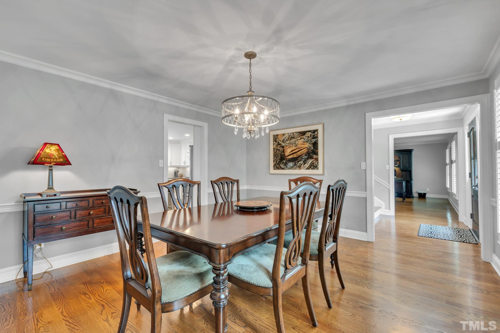 1617 Hunting Ridge Road Raleigh, NC 27615 - Photo 4 of 31 a dining room with furniture a chandelier and wooden floor