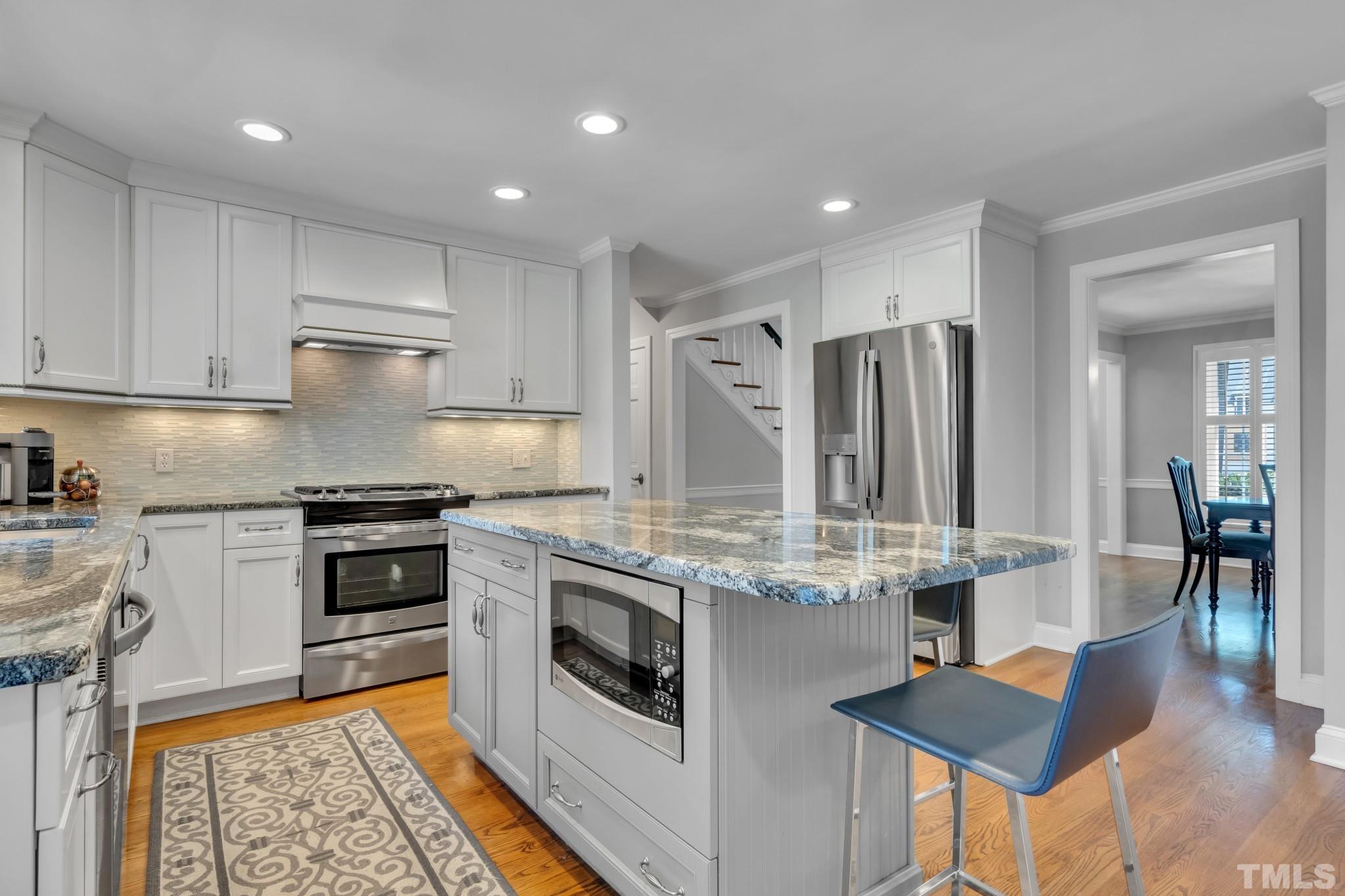 1617 Hunting Ridge Road Raleigh, NC 27615 - Photo 10 of 31 a kitchen with granite countertop kitchen island stainless steel appliances a stove a sink a refrigerator and cabinets