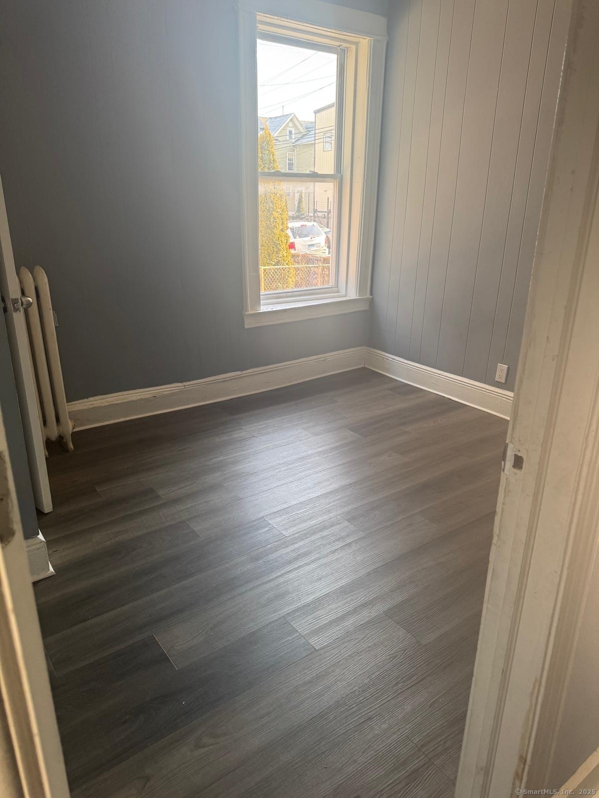 146 George Street, Unit 2 Bridgeport, CT 06604 - Photo 4 of 12 an empty room with wooden floor and windows