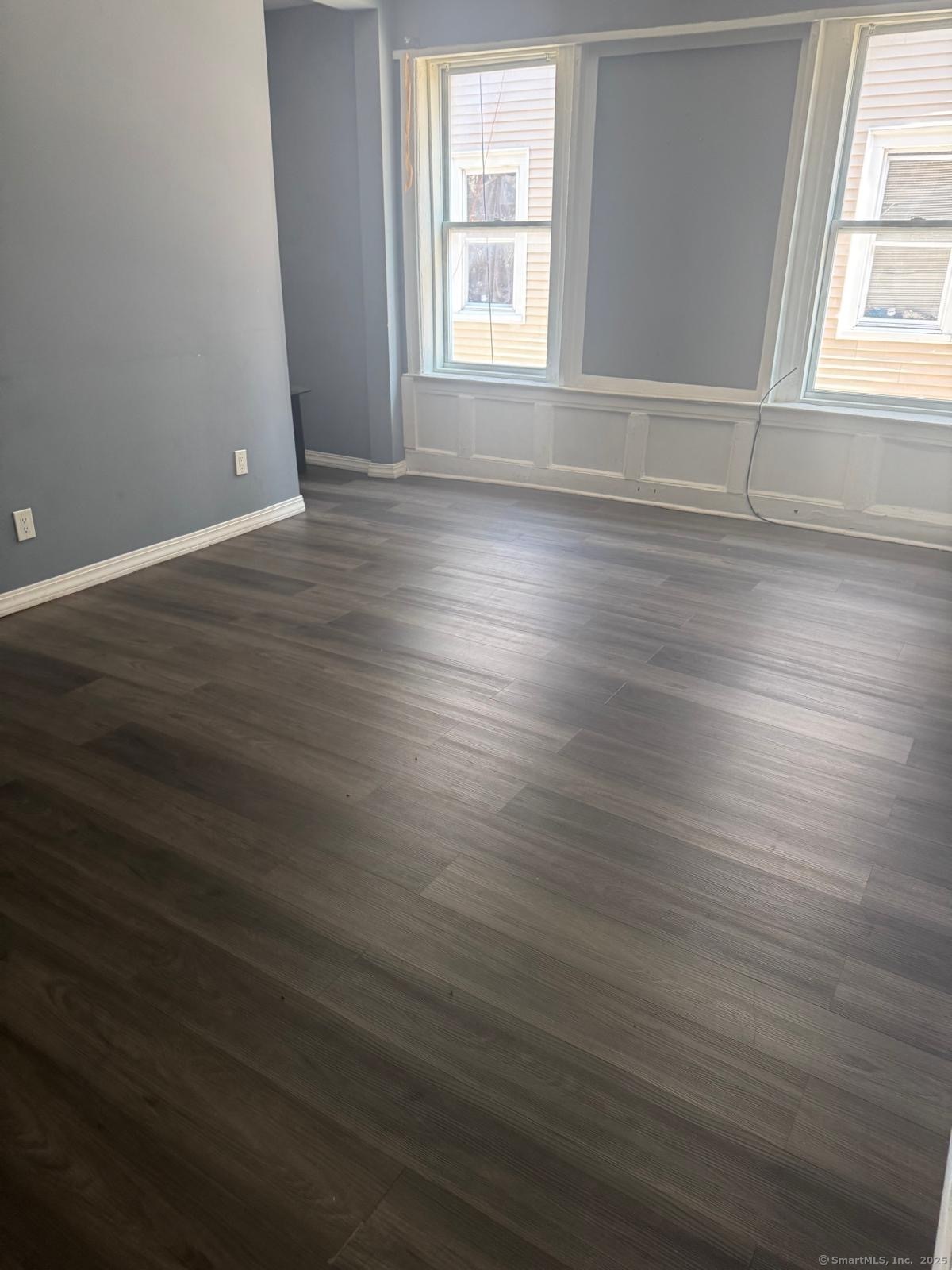 146 George Street, Unit 2 Bridgeport, CT 06604 - Photo 6 of 12 an empty room with wooden floor and windows