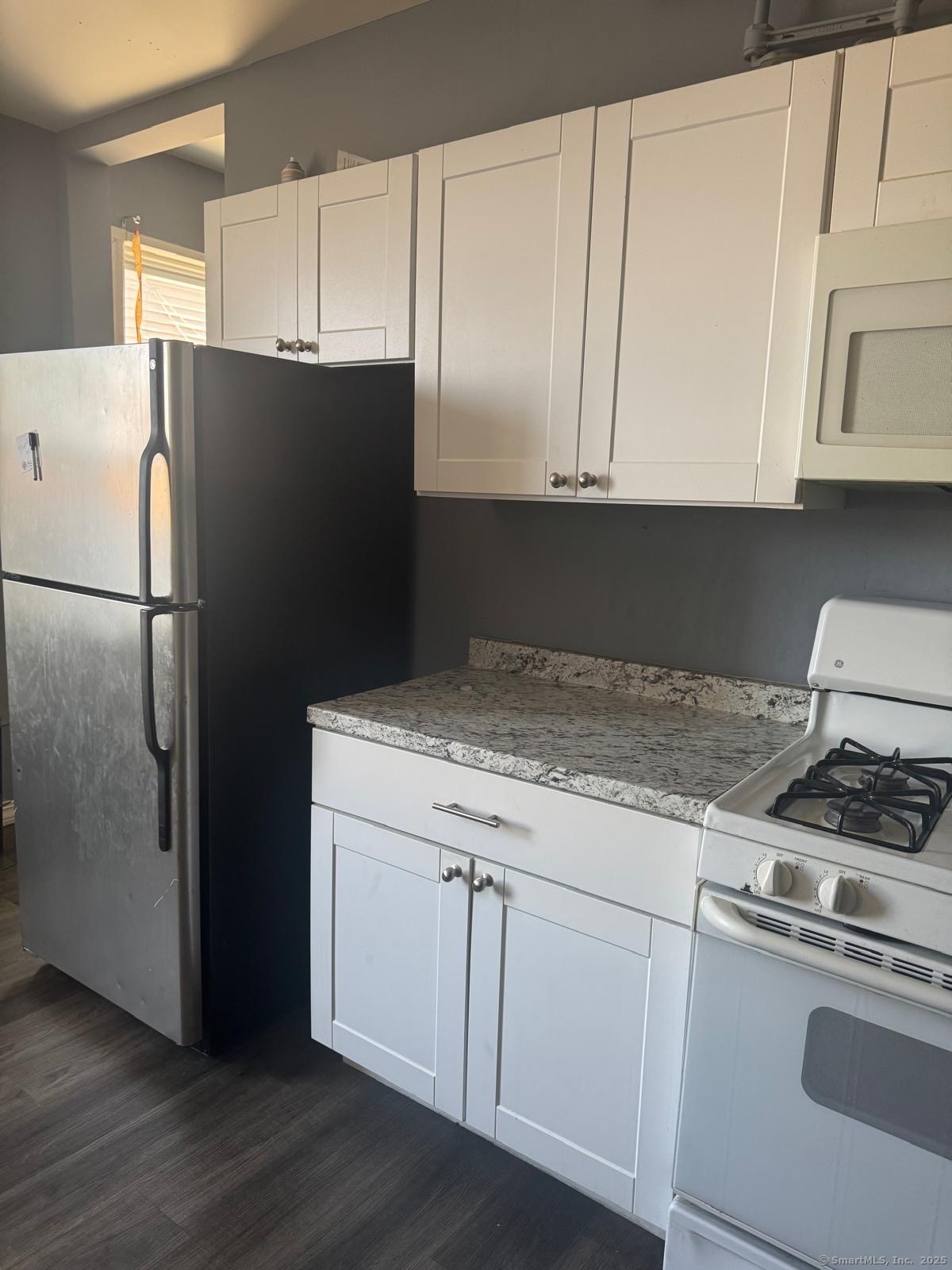 146 George Street, Unit 2 Bridgeport, CT 06604 - Photo 8 of 12 a kitchen with granite countertop white cabinets and refrigerator