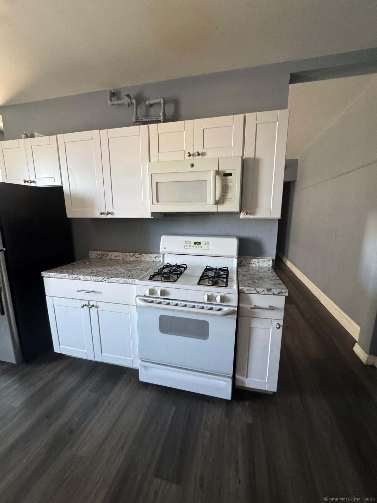 146 George Street, Unit 2 Bridgeport, CT 06604 - Photo 9 of 12 a kitchen with a stove a sink and a microwave