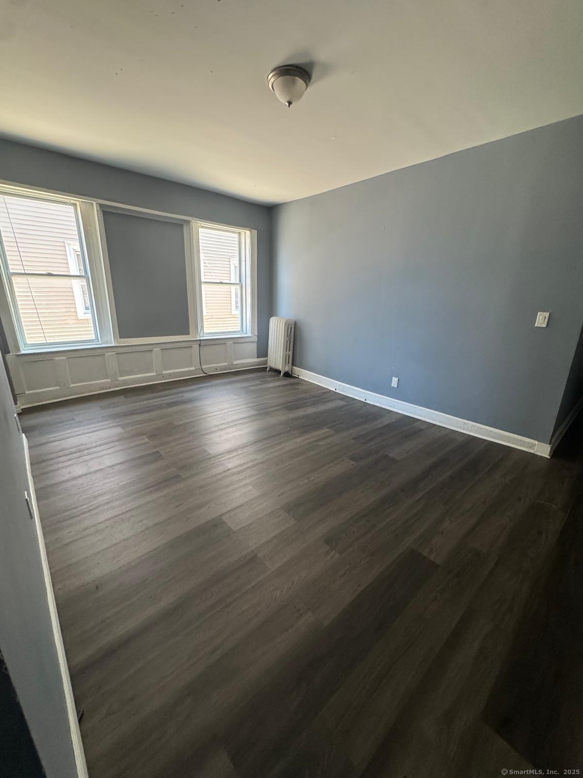 146 George Street, Unit 2 Bridgeport, CT 06604 - Photo 10 of 12 an empty room with wooden floor and windows