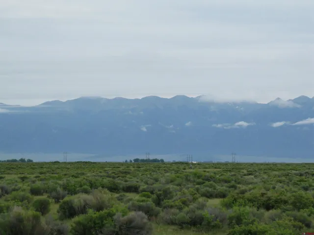 a view of a field with mountains in the background