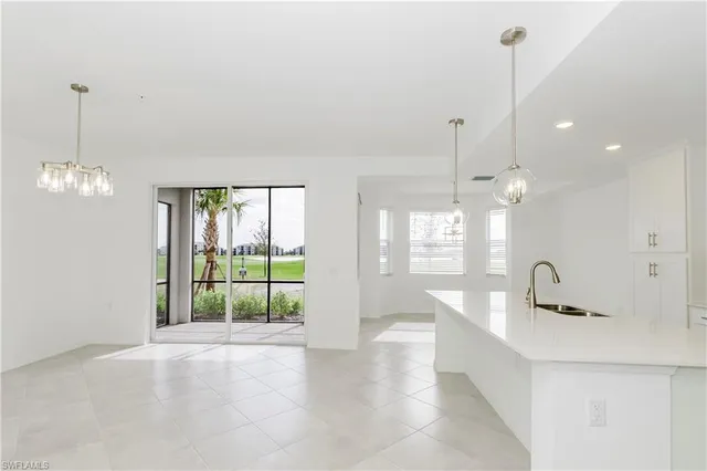 a view of a kitchen with granite countertop a sink and dishwasher with a large window