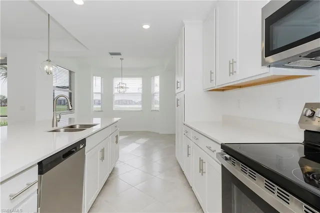 a kitchen with granite countertop white cabinets and appliances