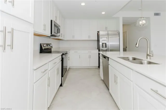 a kitchen with stainless steel appliances granite countertop white cabinets a sink and dishwasher