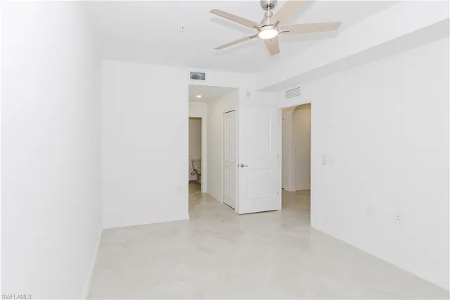 an empty room with a ceiling fan and a window