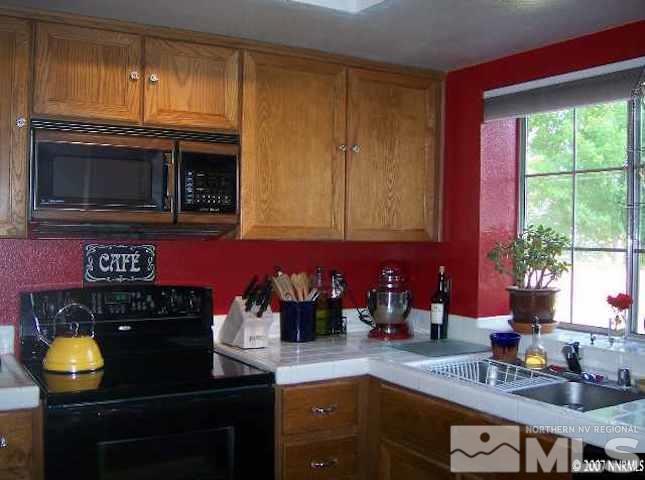 4389 Pescado Way Reno, NV 89502 - Photo 6 of 9 a kitchen with stainless steel appliances granite countertop a stove a sink and a microwave