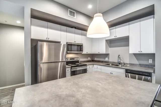 a kitchen with a refrigerator a sink and wooden cabinets