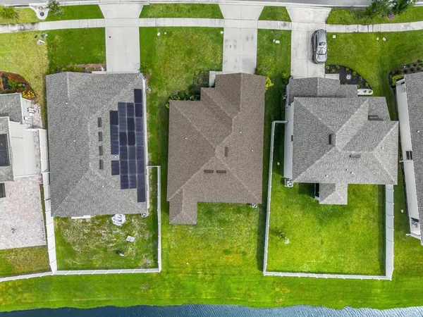 an aerial view of a house with a garden and lake view