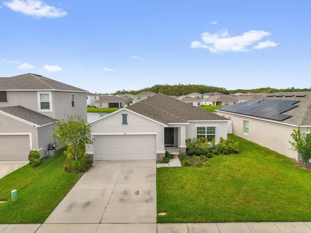 an aerial view of a house with a garden and lake view