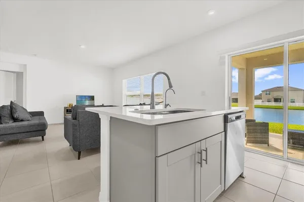 a kitchen with a sink and living room with couches